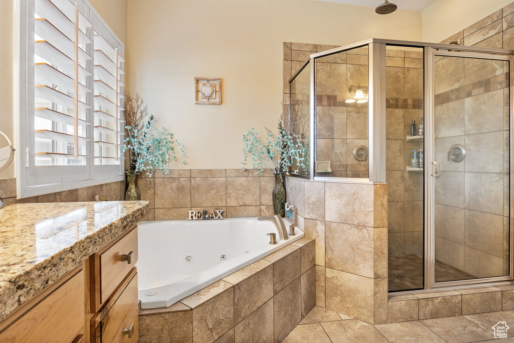 Full bath featuring a tub with jets, a stall shower, and vanity
