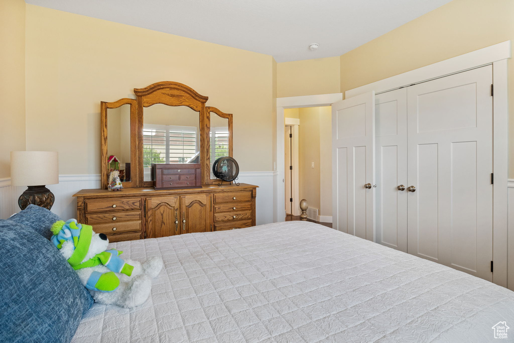 Bedroom with wainscoting and a closet