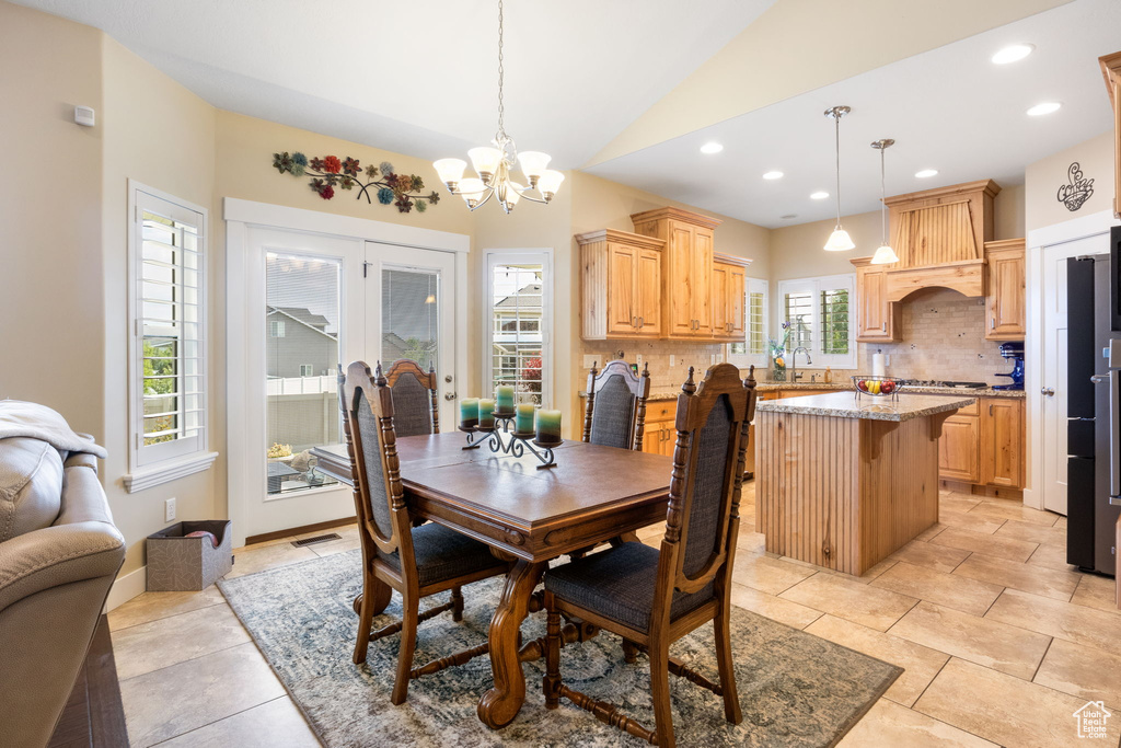 Dining room with lofted ceiling, a chandelier, recessed lighting, and light tile patterned floors