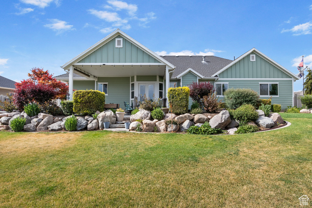 View of front of house with board and batten siding and a front lawn