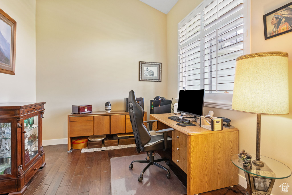 Office with dark wood-style flooring and baseboards