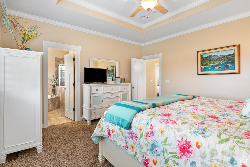 Bedroom featuring crown molding, light carpet, ensuite bathroom, a tray ceiling, and ceiling fan
