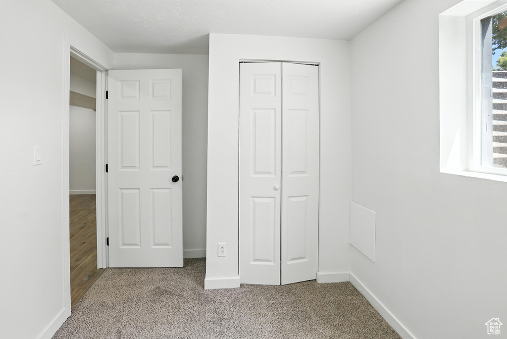 Unfurnished bedroom featuring carpet and a closet