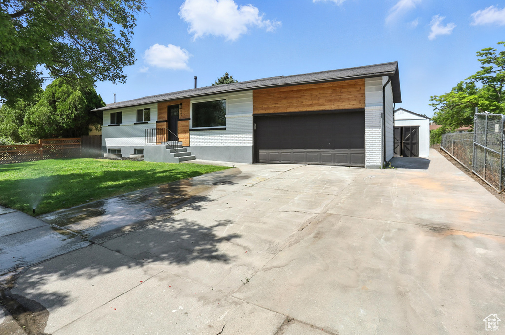 View of front of home with brick siding, an attached garage, and concrete driveway