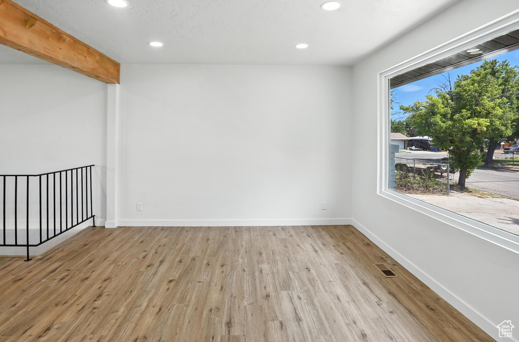Empty room featuring recessed lighting, wood finished floors, and beam ceiling