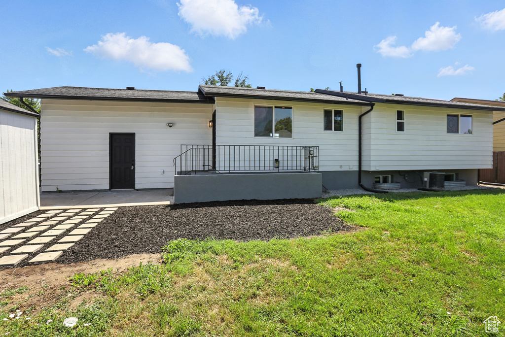 Back of property featuring a yard and a patio