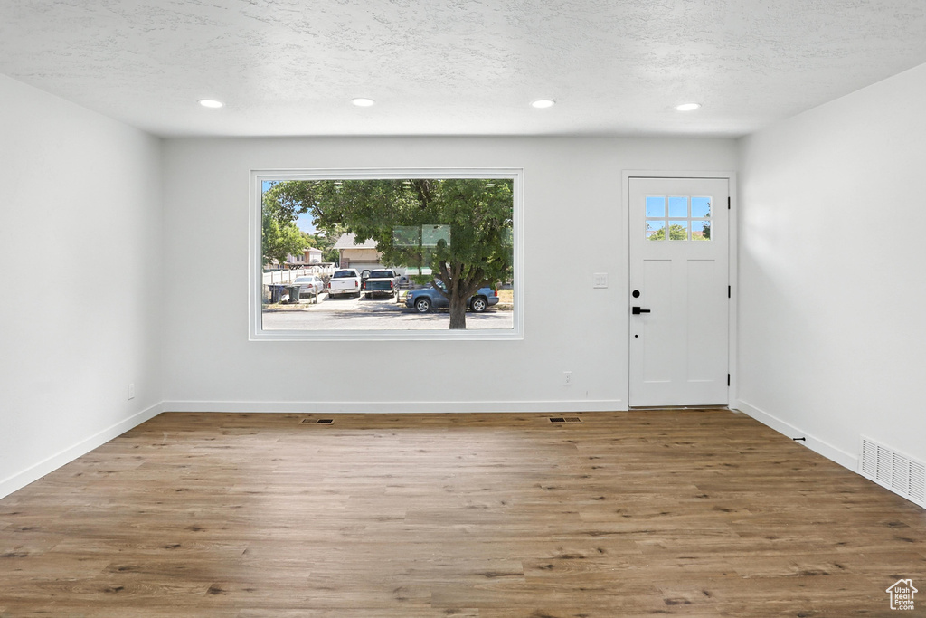 Foyer entrance with a textured ceiling, wood finished floors, and recessed lighting