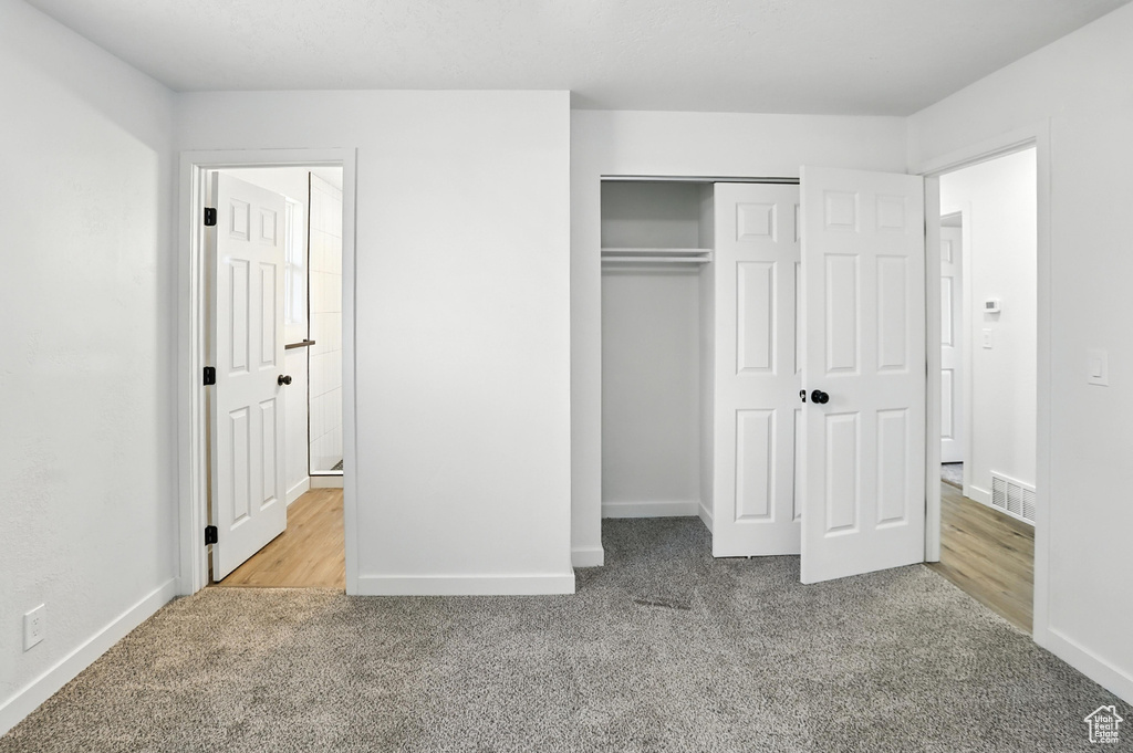 Unfurnished bedroom featuring carpet flooring and a closet
