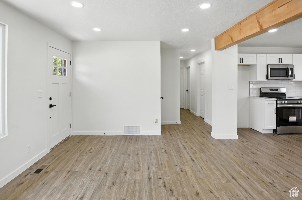 Unfurnished living room with light wood-style flooring and recessed lighting