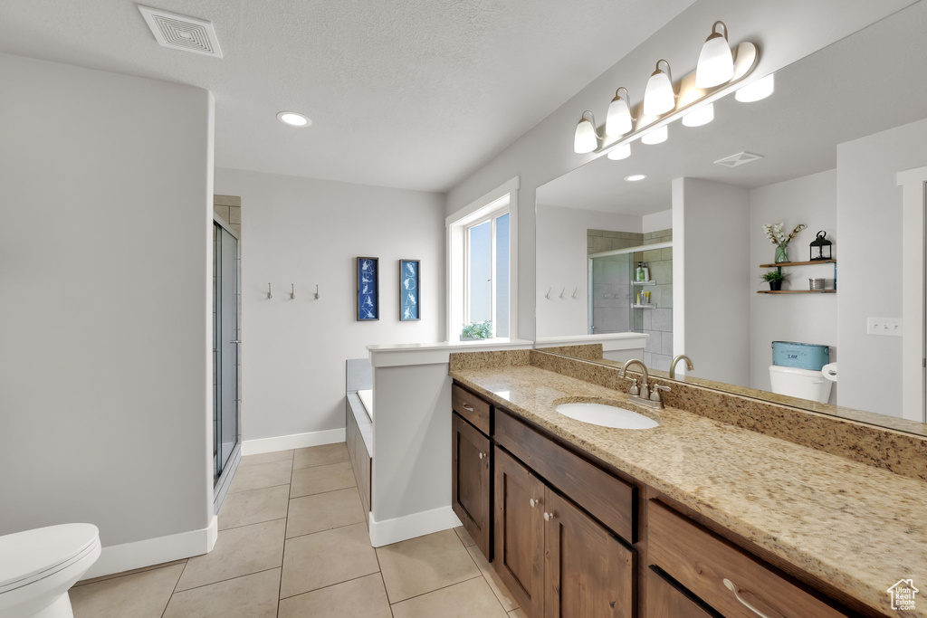 Full bathroom featuring a stall shower, vanity, tile patterned floors, a bath, and recessed lighting
