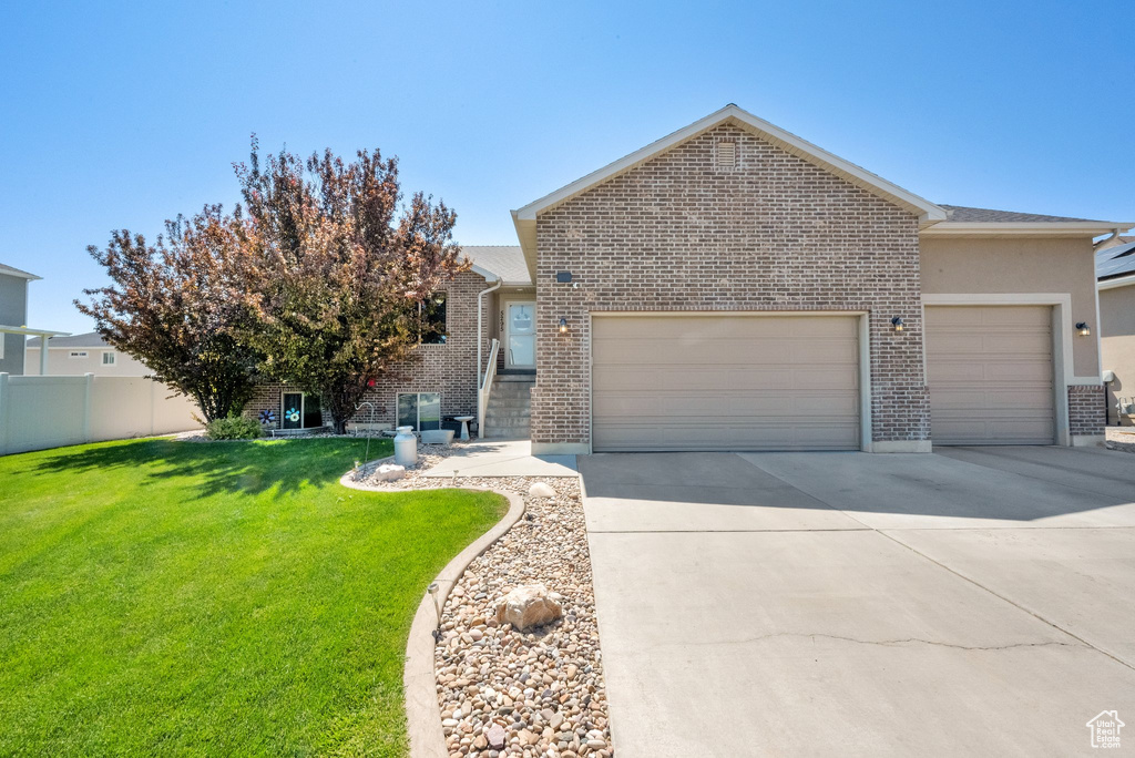 View of front of home featuring an attached garage, driveway, and brick siding