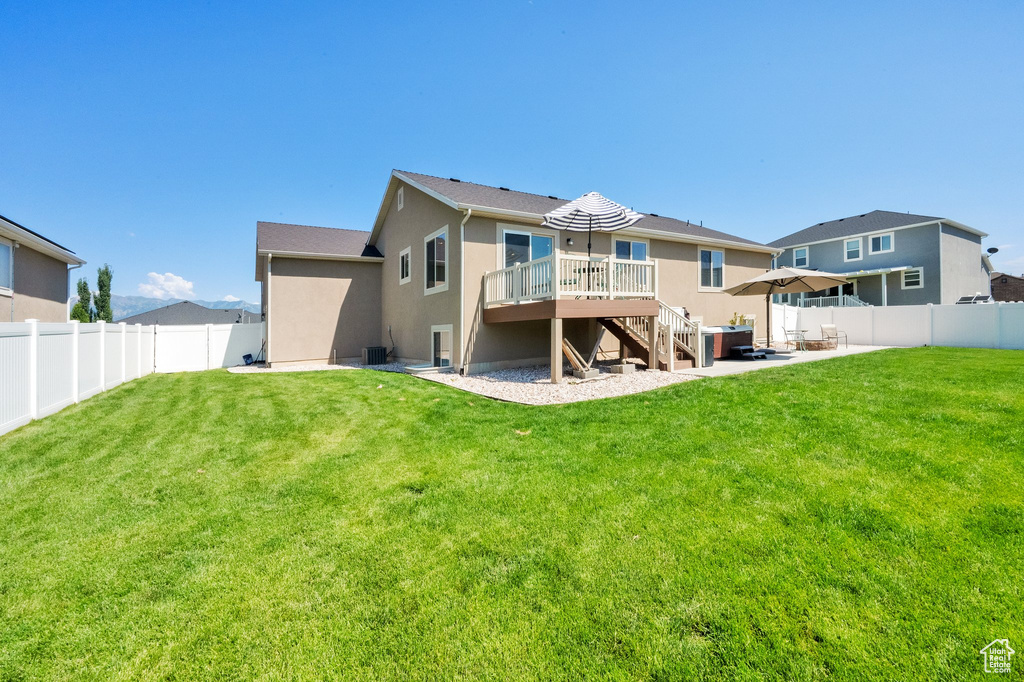 Rear view of property featuring stairway, a fenced backyard, a deck, and stucco siding