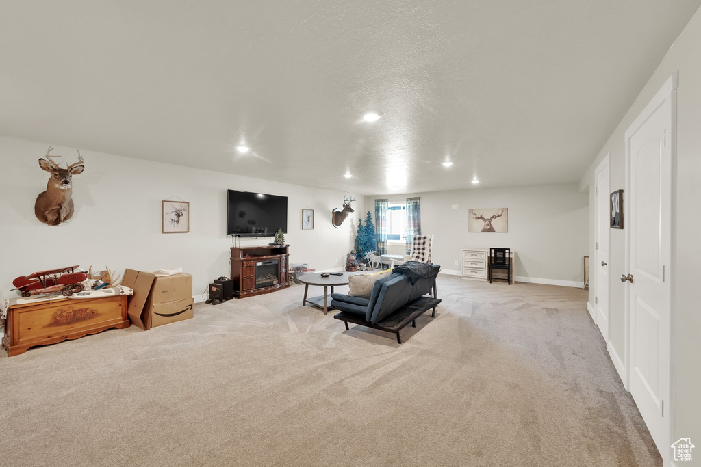 Carpeted living area featuring recessed lighting and baseboards