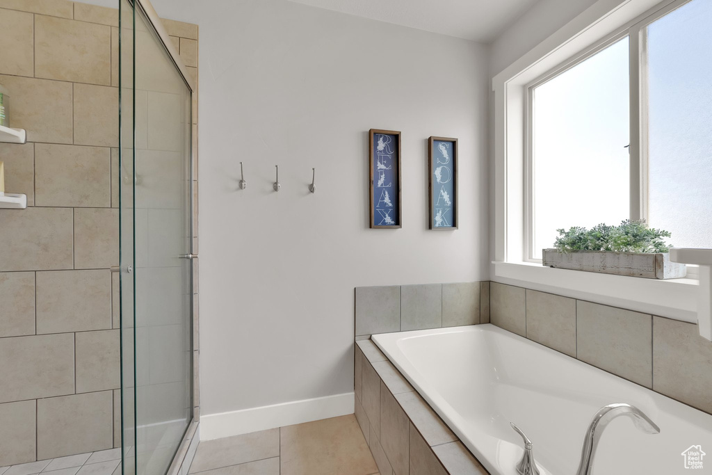 Full bath with tile patterned flooring, a garden tub, and a stall shower