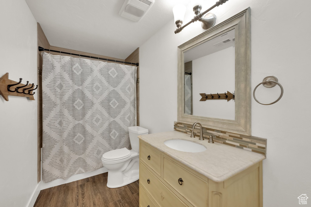 Bathroom with vanity, backsplash, wood finished floors, and a shower with shower curtain