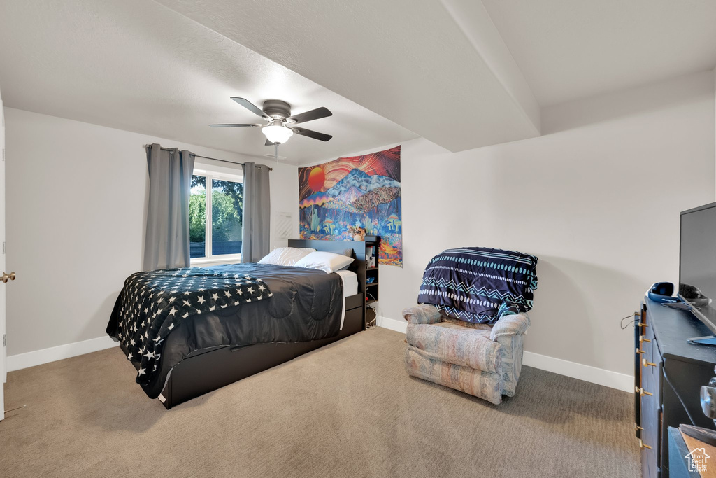 Carpeted bedroom with baseboards and a ceiling fan