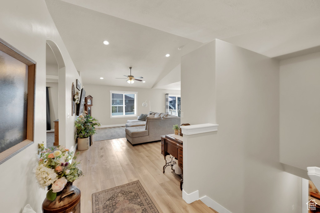 Hallway featuring light wood-type flooring, recessed lighting, and vaulted ceiling