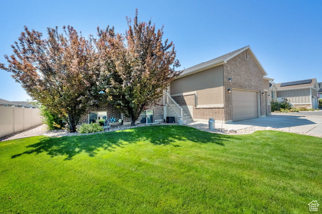 View of front of home with brick siding, driveway, and a garage