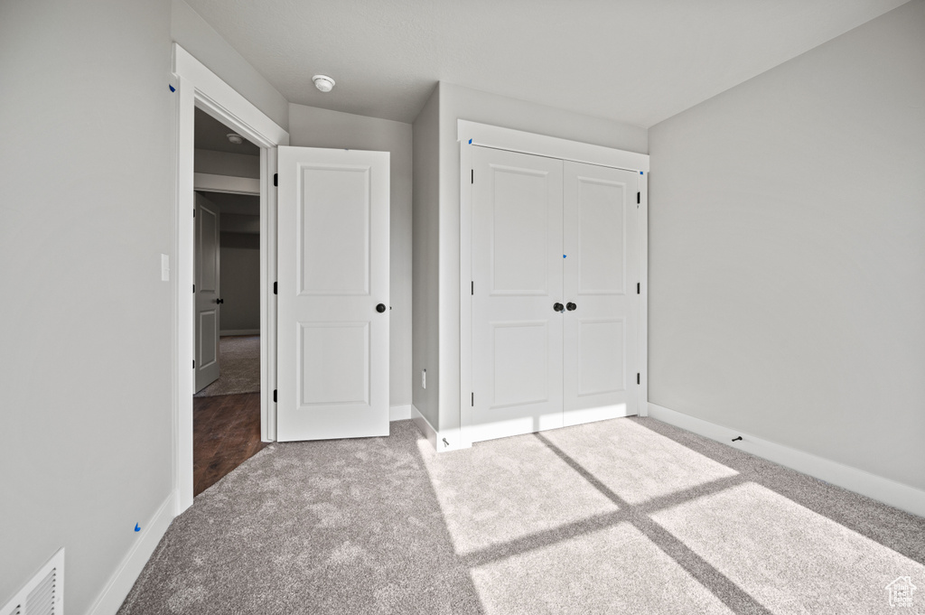 Unfurnished bedroom featuring carpet flooring and a closet