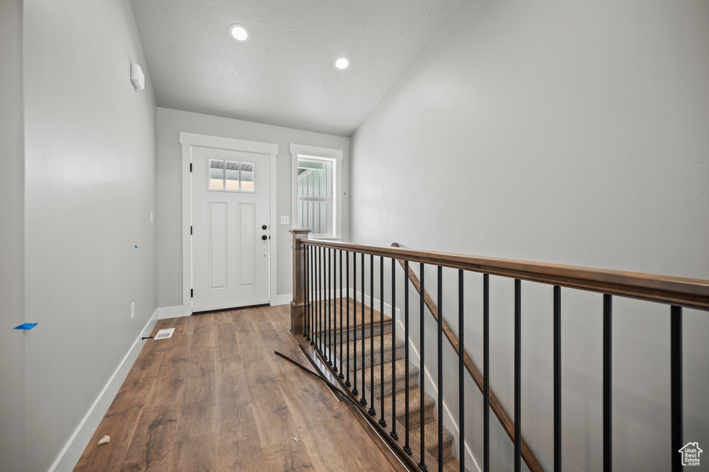 Foyer with wood finished floors and recessed lighting
