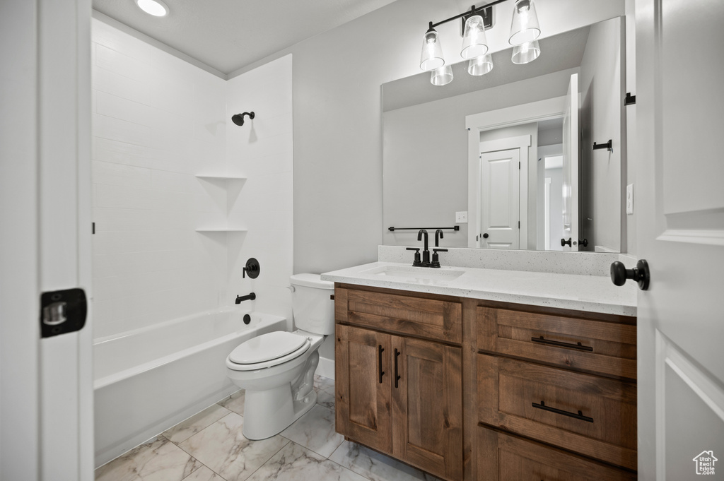 Bathroom featuring vanity, bathtub / shower combination, and marble finish flooring
