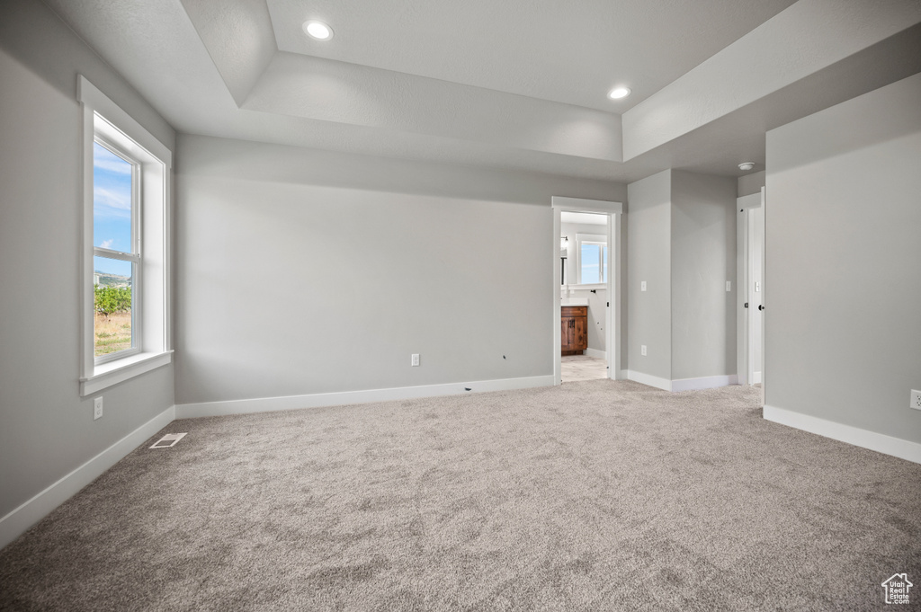 Carpeted spare room with a tray ceiling and recessed lighting
