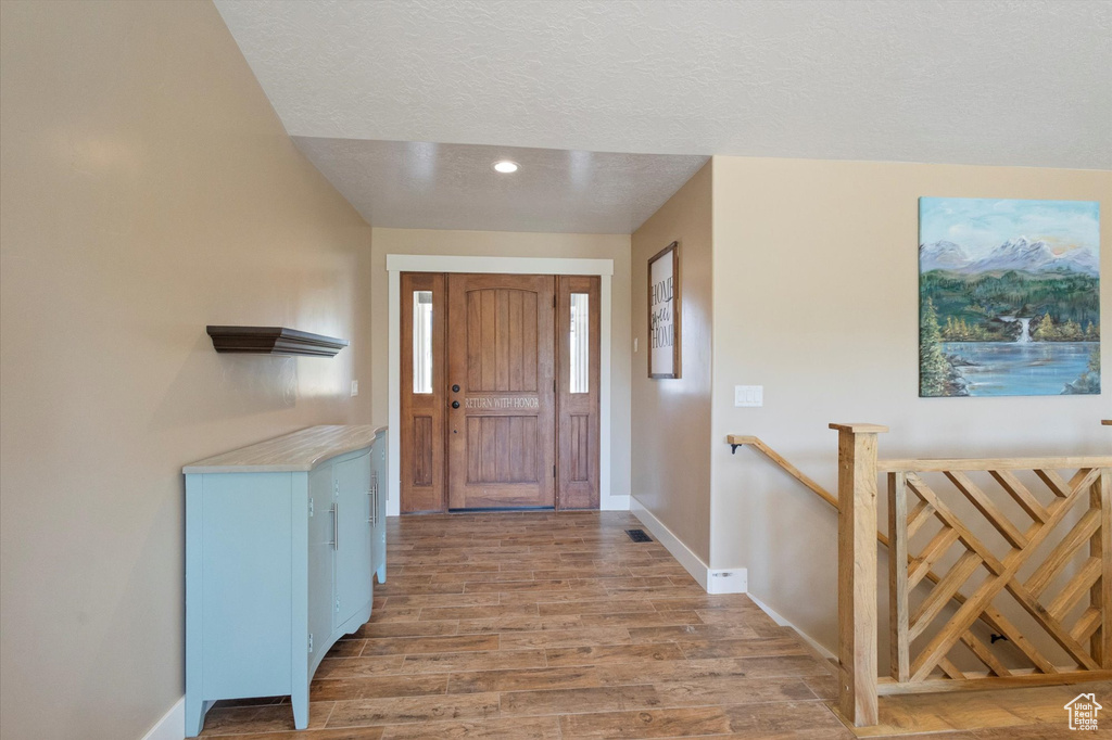 Entryway featuring light wood finished floors, a textured ceiling, and recessed lighting