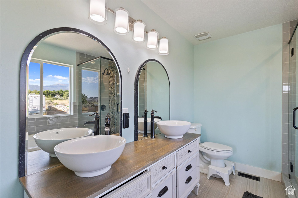Bathroom featuring a shower stall and double vanity
