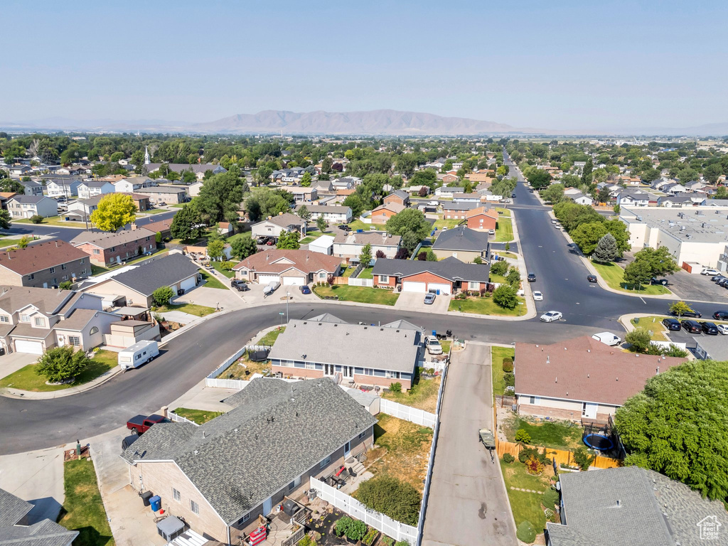 Aerial view of property and surrounding area featuring nearby suburban area and mountains