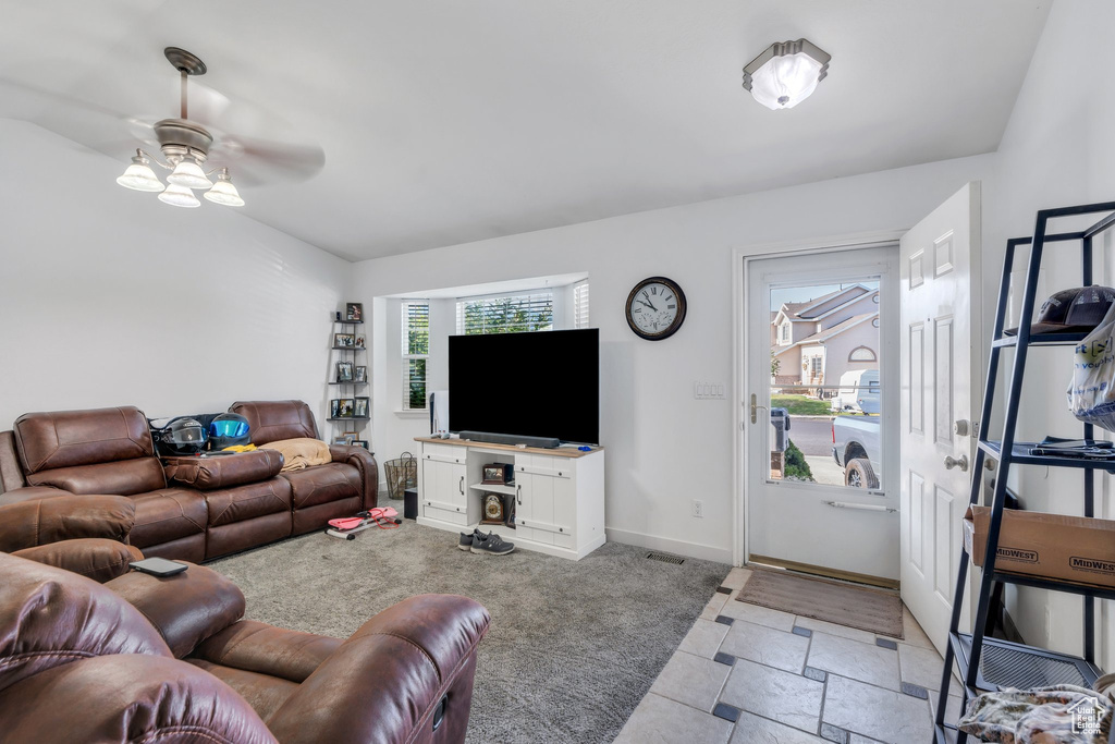 Living area with a ceiling fan and baseboards
