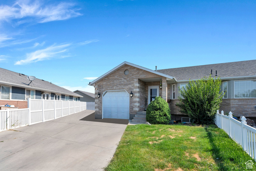 Ranch-style home with a garage, driveway, and brick siding