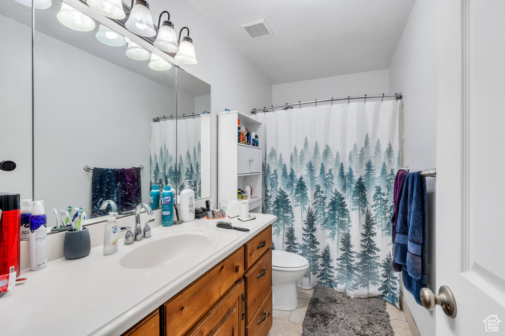 Bathroom with vanity, tile patterned floors, and a shower with shower curtain