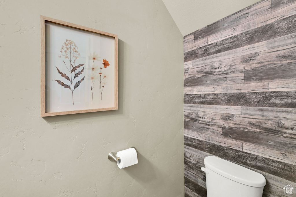 Bathroom with wood walls and lofted ceiling