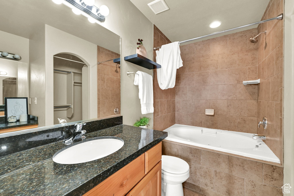 Full bathroom with tiled shower / bath combo and vanity