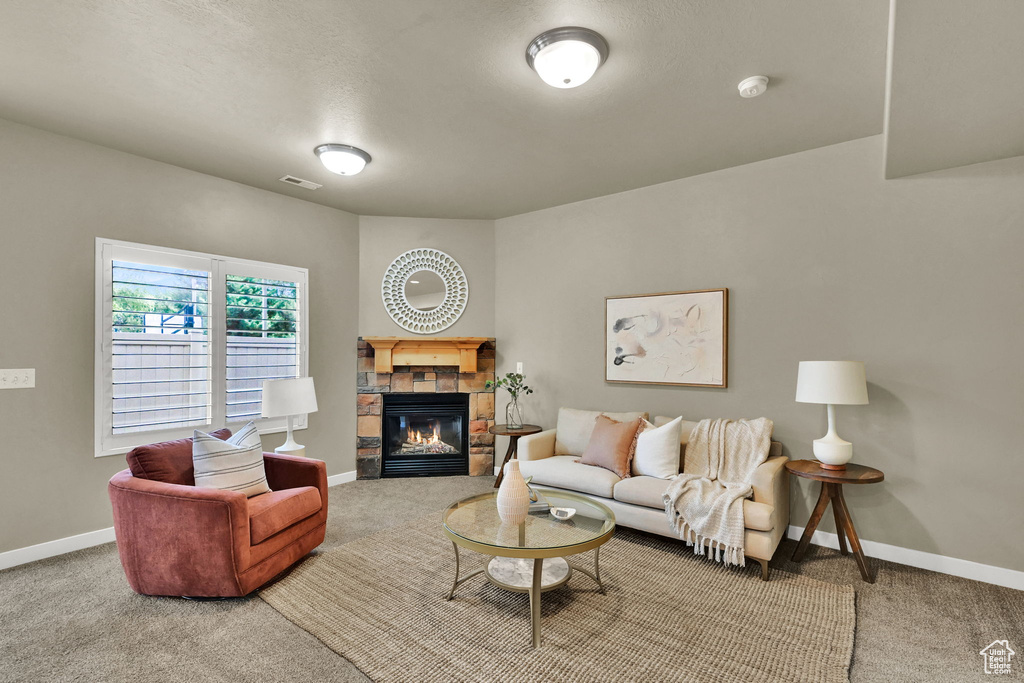 Carpeted living area with baseboards and a fireplace