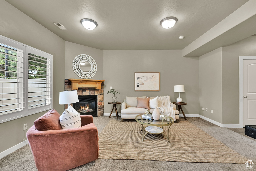 Living area with a tile fireplace and carpet flooring