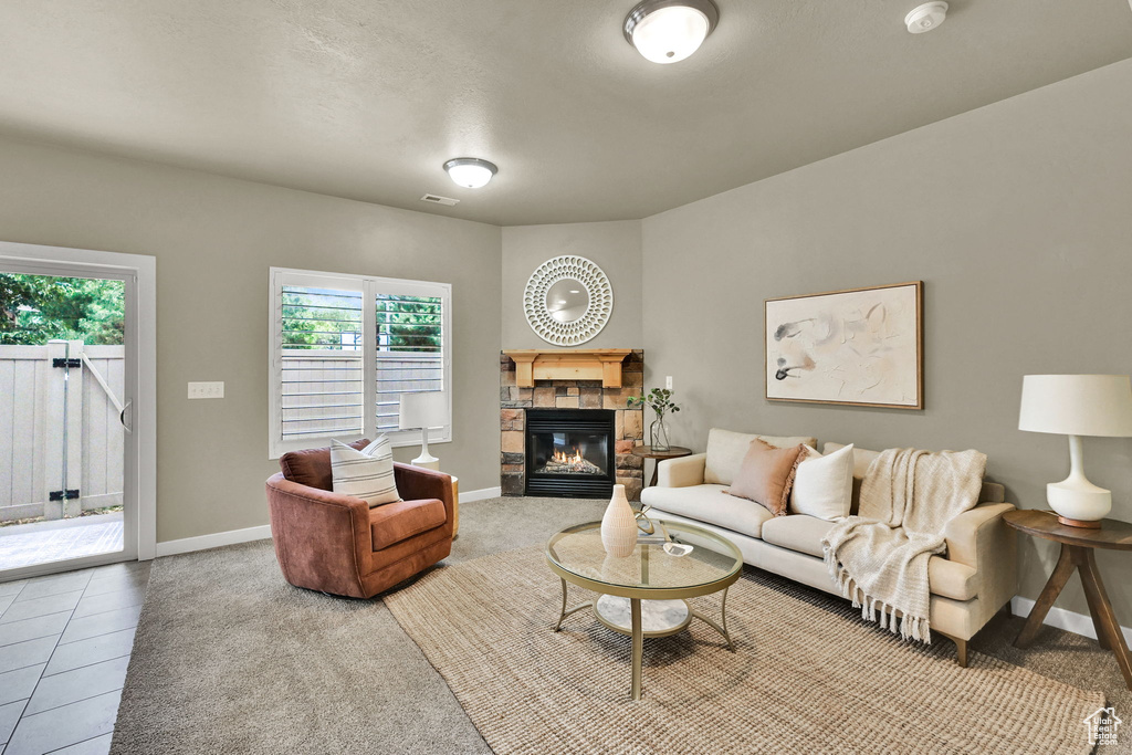 Carpeted living room with a fireplace and baseboards