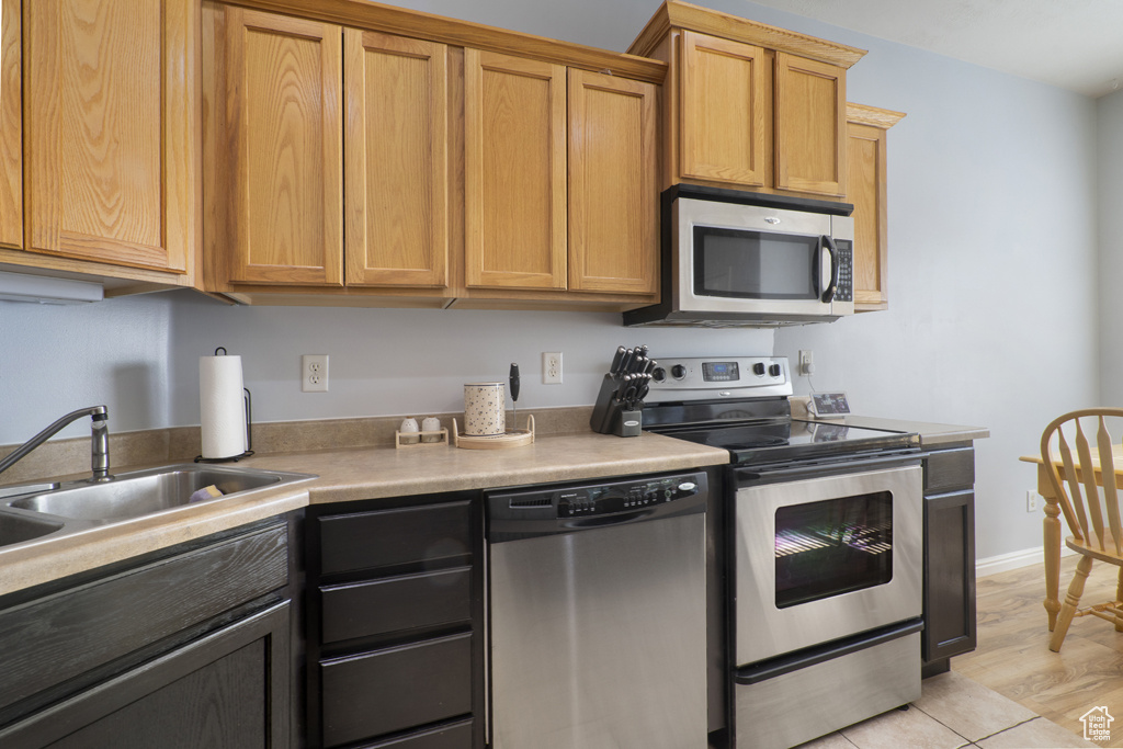 Kitchen with appliances with stainless steel finishes and light countertops