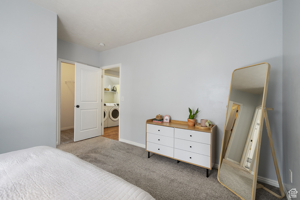 Bedroom featuring separate washer and dryer, carpet, and a spacious closet