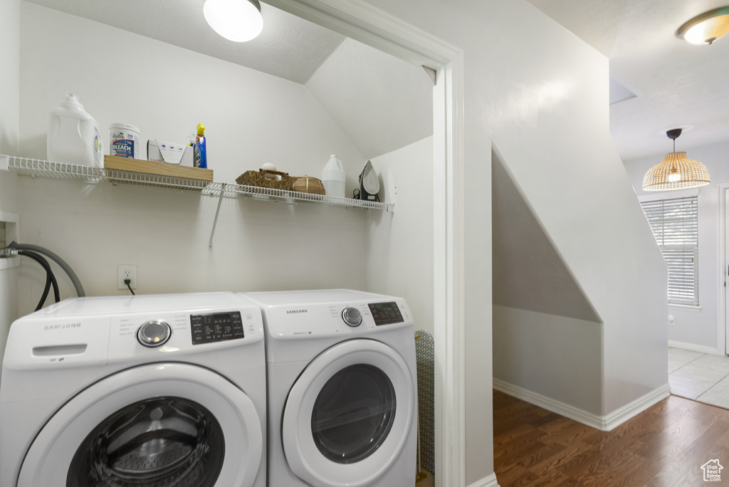 Washroom featuring washing machine and clothes dryer and wood finished floors