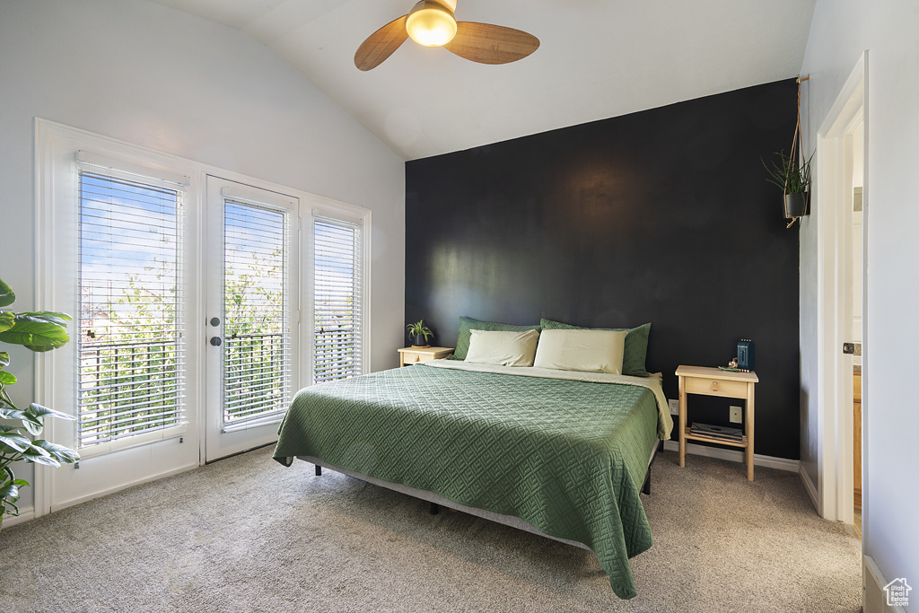 Bedroom featuring access to exterior, multiple windows, carpet flooring, vaulted ceiling, and a ceiling fan