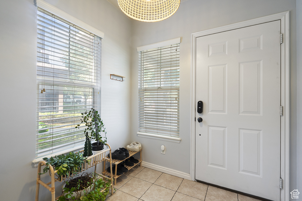 Foyer entrance featuring light tile patterned flooring and healthy amount of natural light