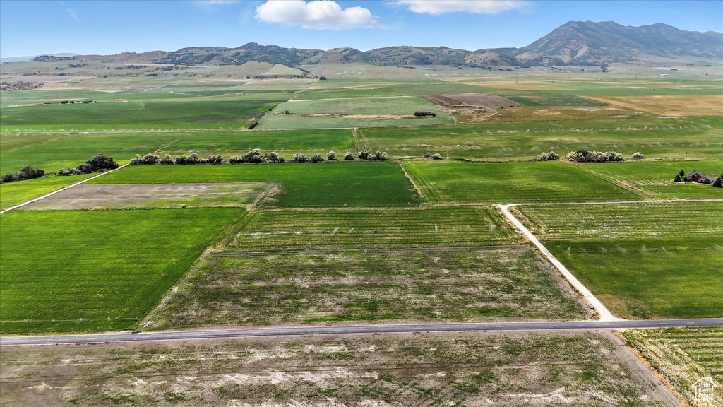 Aerial view of sparsely populated area featuring a mountainous background and large plots for crops