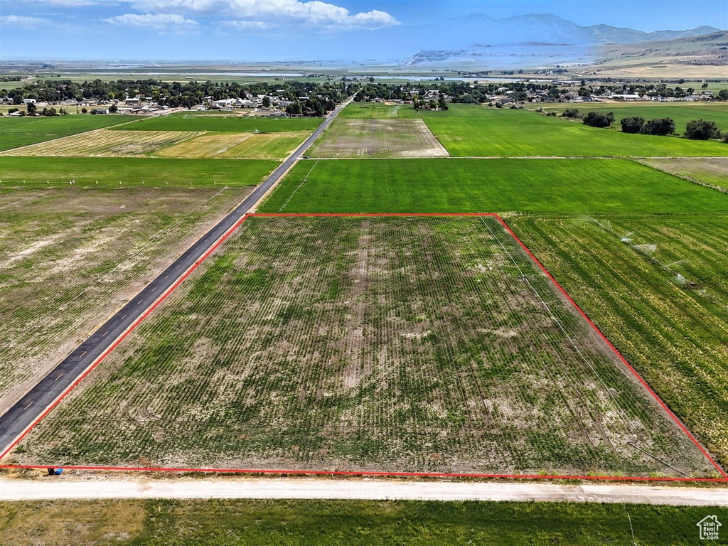 Overview of rural landscape with property boundaries highlighted, rows of crops, and a mountainous background