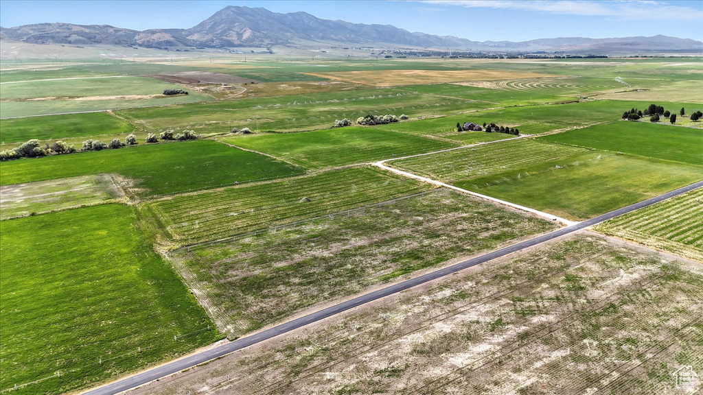 Aerial view of sparsely populated area with a mountainous background and large plots for crops
