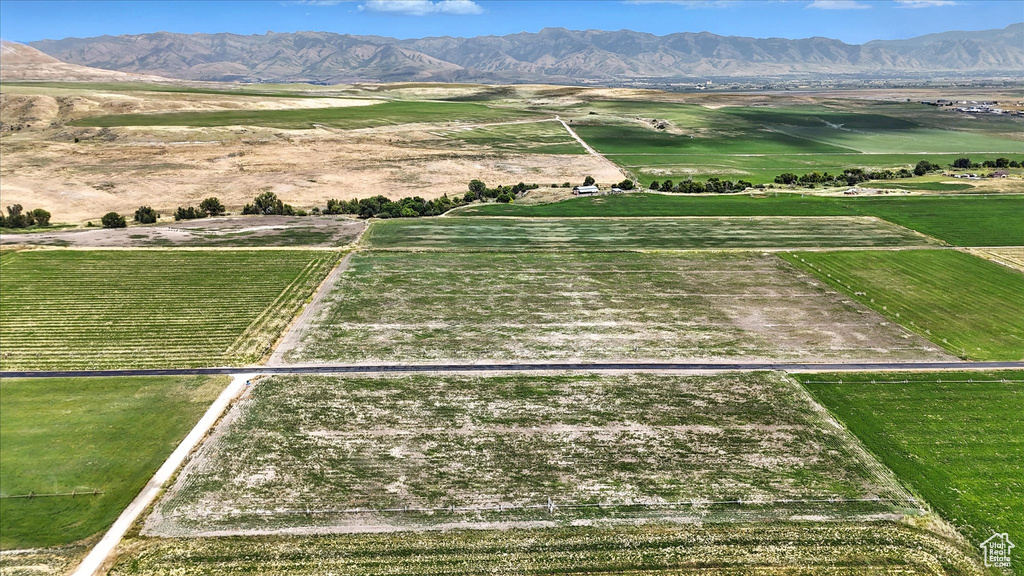 View of rural area featuring a mountain backdrop and large plots for crops