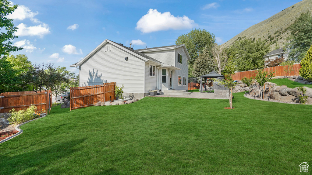 Back of property with a gazebo and a patio area