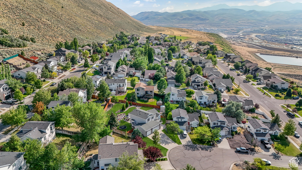 Aerial view of property and surrounding area with nearby suburban area and mountains