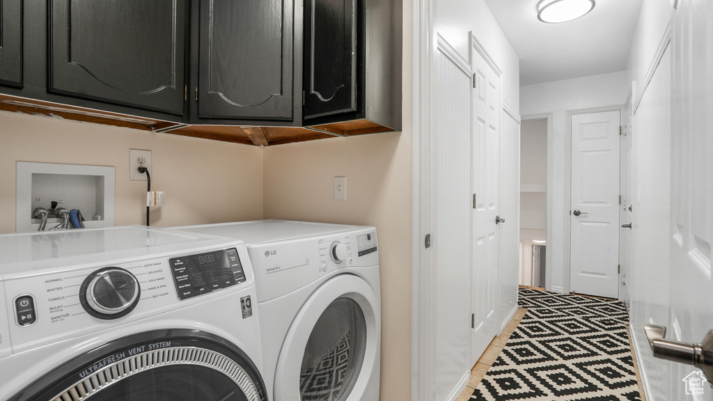 Laundry area featuring cabinet space, separate washer and dryer, and light tile patterned floors