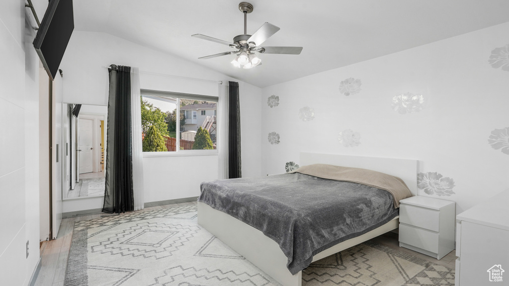 Bedroom featuring lofted ceiling, light wood-style flooring, and ceiling fan